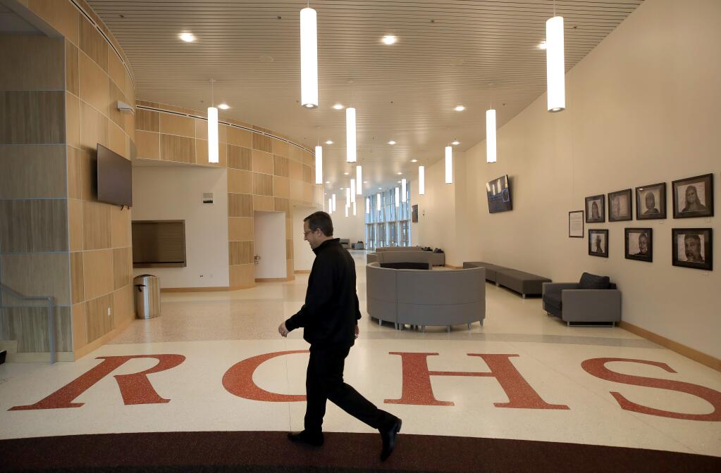 Rancho Cotate High School assistant principal Henri Sarlatte walks to open the theater doors, Thursday, Feb. 13, 2020, in a brand-new $52 million gymnasium and theater arts building on the campus in Rohnert Park. The gym is named after his father, Henry J. Sarlatte. (Kent Porter / The Press Democrat)