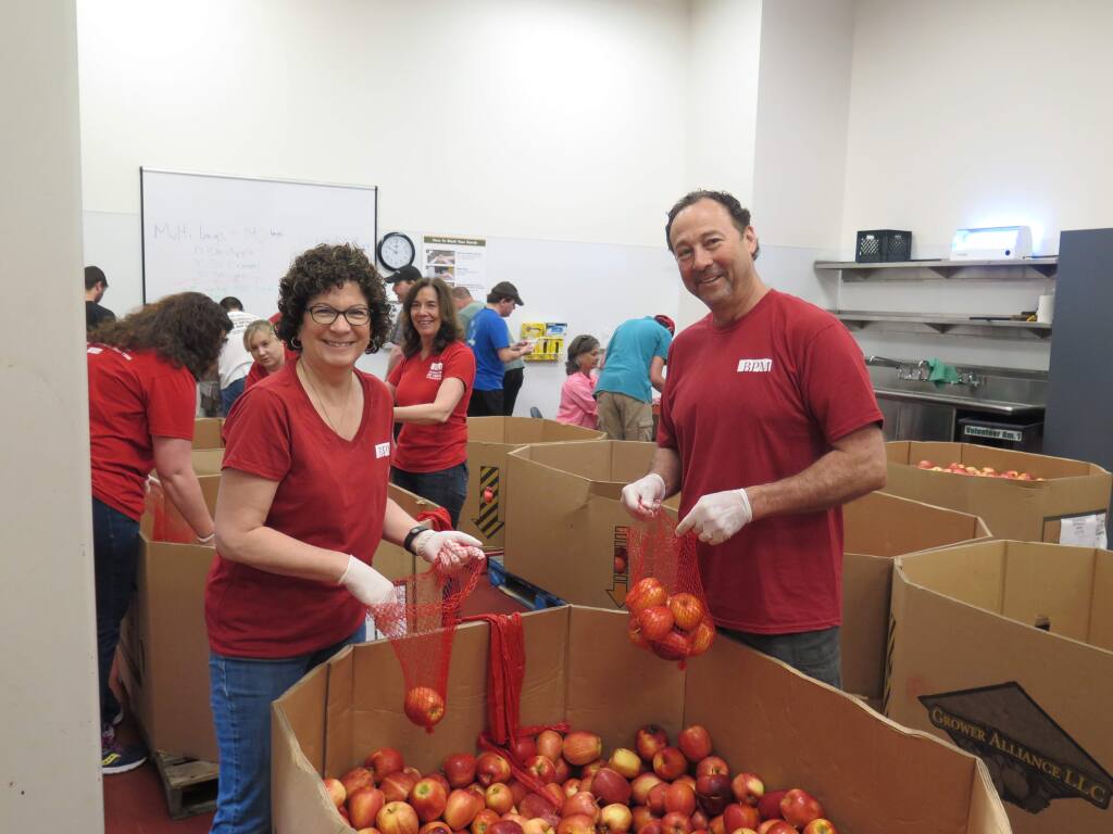 BPM volunteers Jeannie Benton (left) and Tom Benton, along with Other BPM staffers bag apples at the Redwood Empire Food Bank.