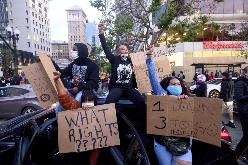 In this May 29, 2020, photo, demonstrators protest in Oakland, Calif., the Monday death of George Floyd, a handcuffed black man in police custody in Minneapolis. (AP Photo/Noah Berger)