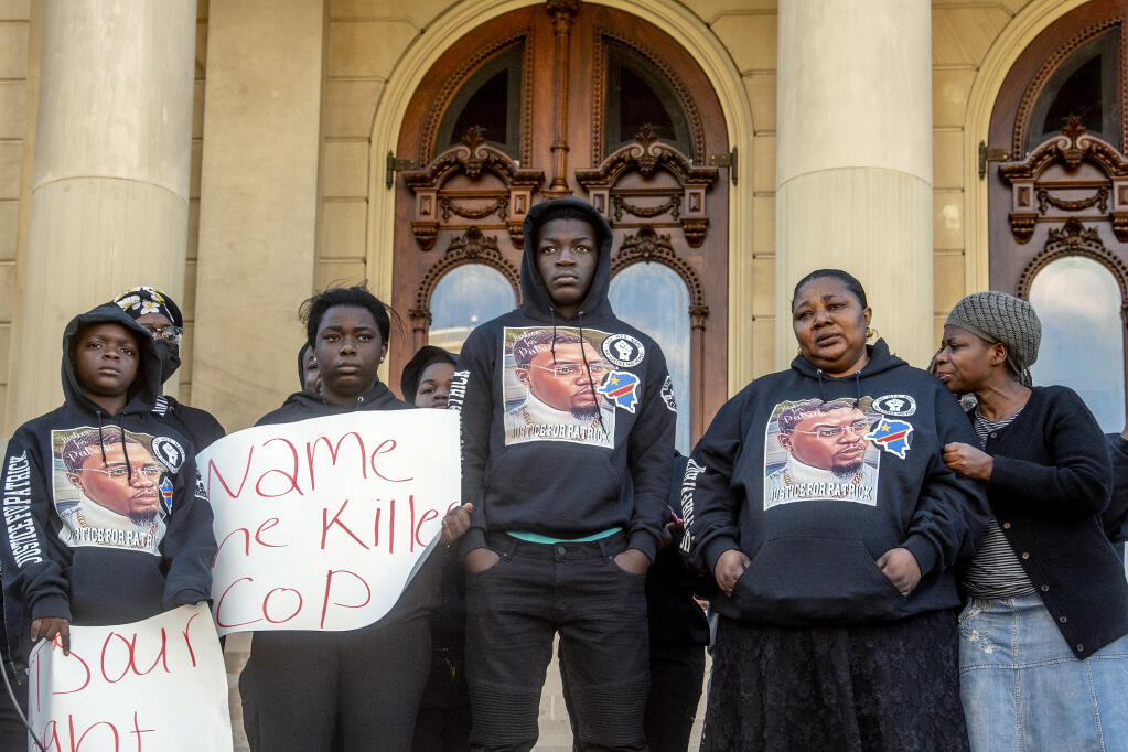 The Lyoya family stands together on the steps of the Michigan Capitol to demand justice in the police shooting that took the life of Congolese immigrant Patrick Lyoya, Thursday, April 21, 2022 in Lansing Mich. (Jake May/The Flint Journal via AP)