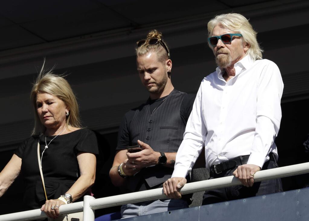 Britain's Richard Branson, right, with his son Sam Branson, center, and wife Joan Templeman join crowds who attend the 16th Annual Nelson Mandela Lecture at the Wanderers Stadium in Johannesburg, South Africa, Tuesday, July 17, 2018 where former US President Barack Obama was to deliver the 16th Annual Nelson Mandela Lecture. Obama urged Africans and people around the world to respect human rights and equal opportunity in his speech to mark the late Nelson Mandela's 100th birthday. (AP Photo/Themba Hadebe)