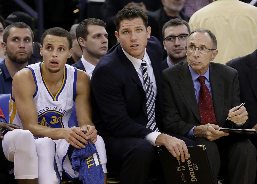 Warriors assistant coaches Ron Adams, right, and Luke Walton, keep an eye on the action along with guard Stephen Curry. (Jeff Chiu / Associated Press)