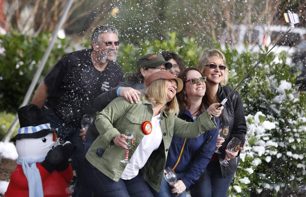 A group of friends use an extended selfie arm to take a photo of themselves as bubbles float around like snow at Chateau Diana as part of the 23rd Annual Winter WINEland event on Sunday, January 18, 2015 in Healdsburg, California . (BETH SCHLANKER/ The Press Democrat)