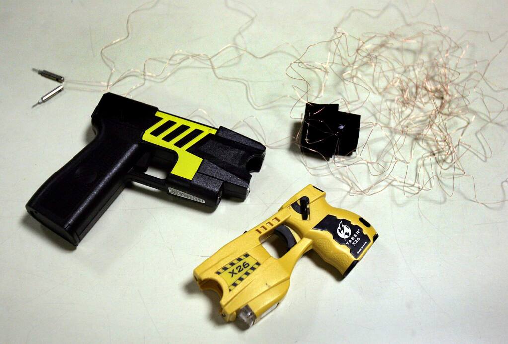 File Photo: Examples of two models of taser with a spent cartridge with fires 21 feet of insulated copper wire with two probes at the end.(John Burgess/PD)