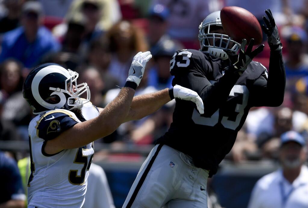Los Angeles Rams linebacker Bryce Hager, left, breaks up a pass intended for Oakland Raiders tight end Marcus Baugh during the first half in an NFL preseason football game Saturday, Aug. 18, 2018, in Los Angeles. (AP Photo/Kelvin Kuo)