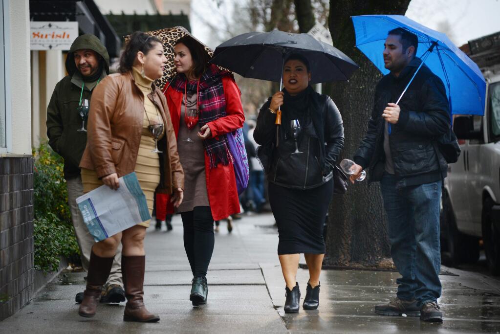 From left, Edward Zuniga, from El Monte, California, Maria Ross, from Hopland; Divna Lazil, from Alhambra; and Erica and David Cortez, both from Whittier, touring wine tasting rooms during a light rain in downtown Healdsburg Sunday, Jan. 17 during the 24th annual Winter Wineland. (Erik Castro / for The Press Democrat)