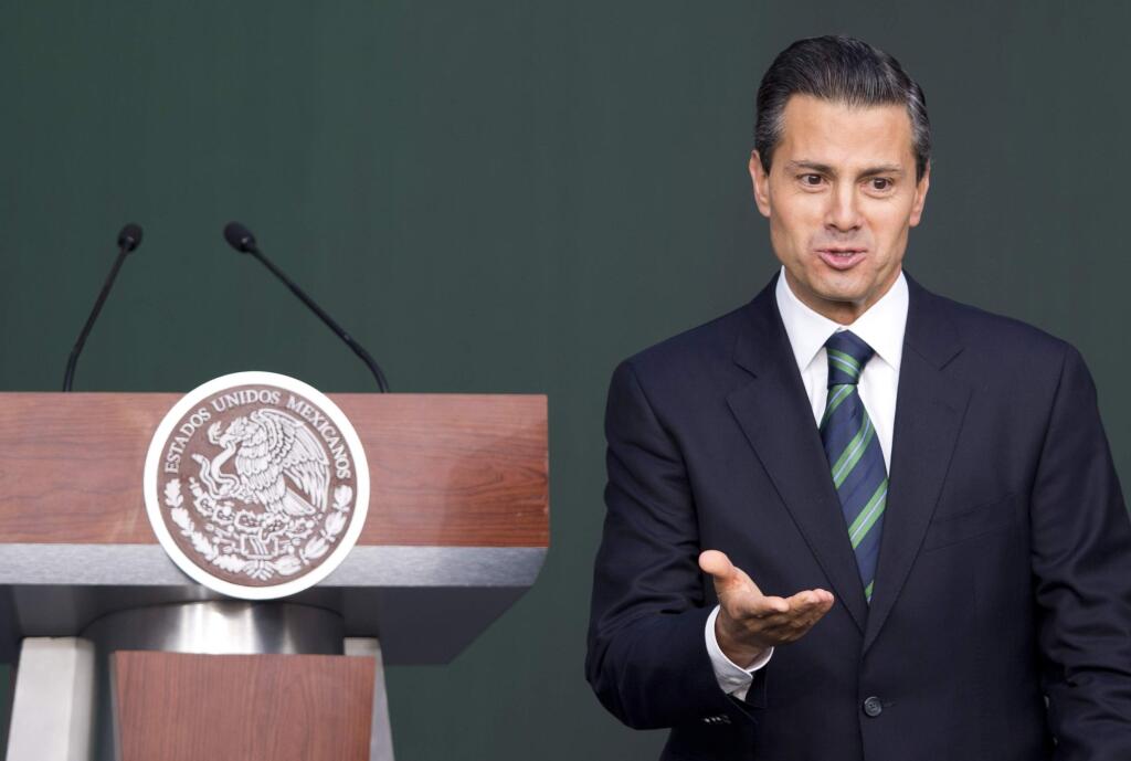 Mexico's President Enrique Pena Nieto gestures after addressing the audience during a ceremony at the National Palace in Mexico City, Thursday, Nov. 27, 2014. Mexico's president announced a new anti-crime plan that includes proposals for a nationwide ID, giving Congress the power to dissolve corrupt municipal government and fold their often-corrupt local police forces under the control of the countrys 31 state governments. The plan would also streamline the complex divisions between federal, state and local offenses. At present, some local police refuse to act to prevent federal crimes like drug trafficking. The plan would focus first on four of Mexicos most troubled states, Guerrero, Michoacan, Jalisco and Tamaulipas. It would also send more federal police and other forces to those states. (AP Photo/Eduardo Verdugo)