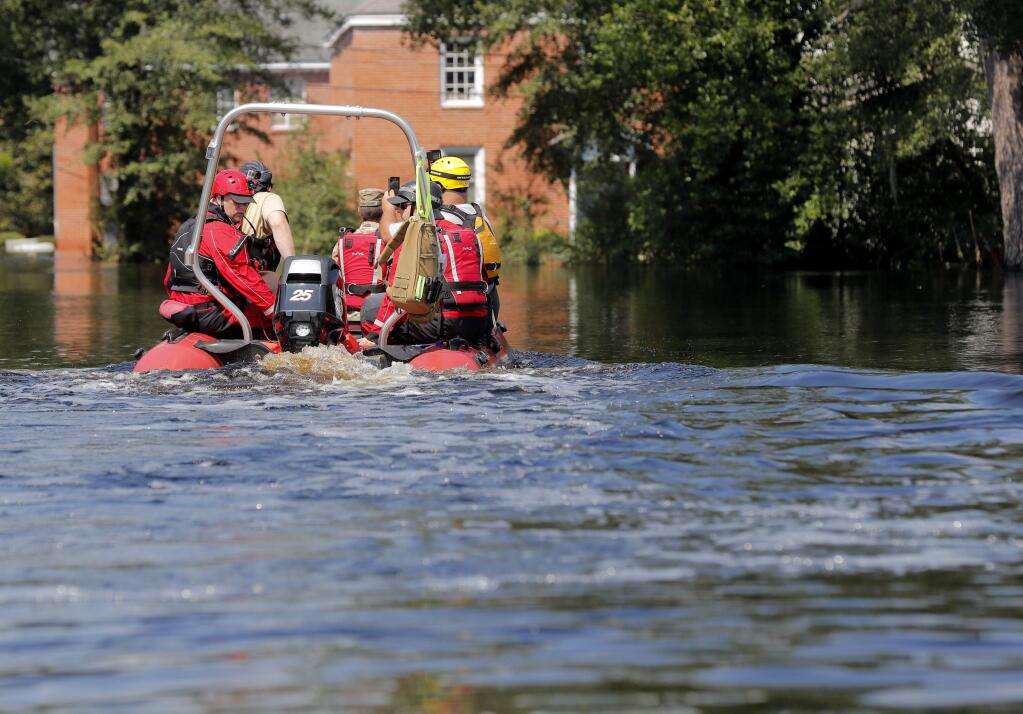 A swift recuse boat motors through floodwaters in the aftermath of Hurricane Florence in Nichols, S.C., Friday, Sept. 21, 2018. Virtually the entire town is flooded and inaccessible except by boat, just two years after it was flooded by Hurricane Matthew. (AP Photo/Gerald Herbert)