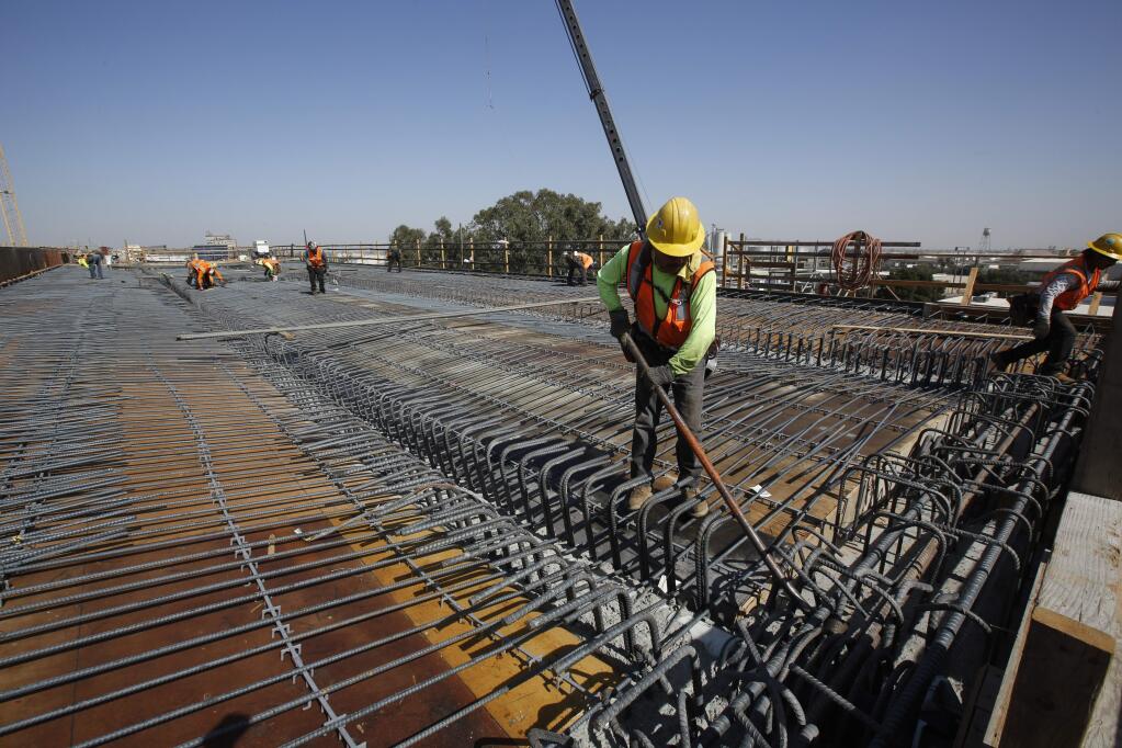 FILE - In this Oct. 9, 2019, file photo, a steel rebar is placed before concrete is poured on the high speed rail viaduct that will cross over Highway 99 in Fresno, Calif. The California High-Speed Rail Authority on Wednesday, Feb. 12, 2020, bumped its overall cost estimate for completing the rail line between San Francisco and Los Angeles to $80.3 billion, blaming inflationary increases and better cost projections for a $1.3 billion boost that still is smaller than in previous years. (AP Photo/Rich Pedroncelli, File)