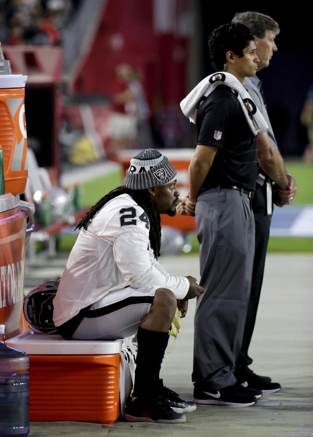 Oakland Raiders running back Marshawn Lynch (24) sits during the national anthem prior to the team's NFL preseason football game against the Arizona Cardinals, Saturday, Aug. 12, 2017, in Glendale, Ariz. (AP Photo/Rick Scuteri)