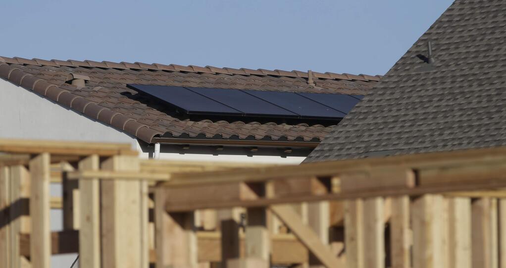 Solar panels are seen on the rooftop on a home in a new housing project in Sacramento. The state Energy Commission voted to require solar panels on new homes and low-rise apartment buildings starting in 2020. (RICH PEDRONCELLI / Associated Press)