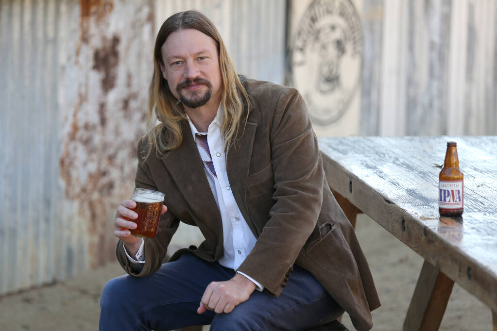 Jeremy Marshall, brewmaster at Lagunitas Brewing Company, holds a glass of the newly released non-alcoholic IPA on Dec. 1 in Petaluma. (BETH SCHLANKER/ The Press Democrat)