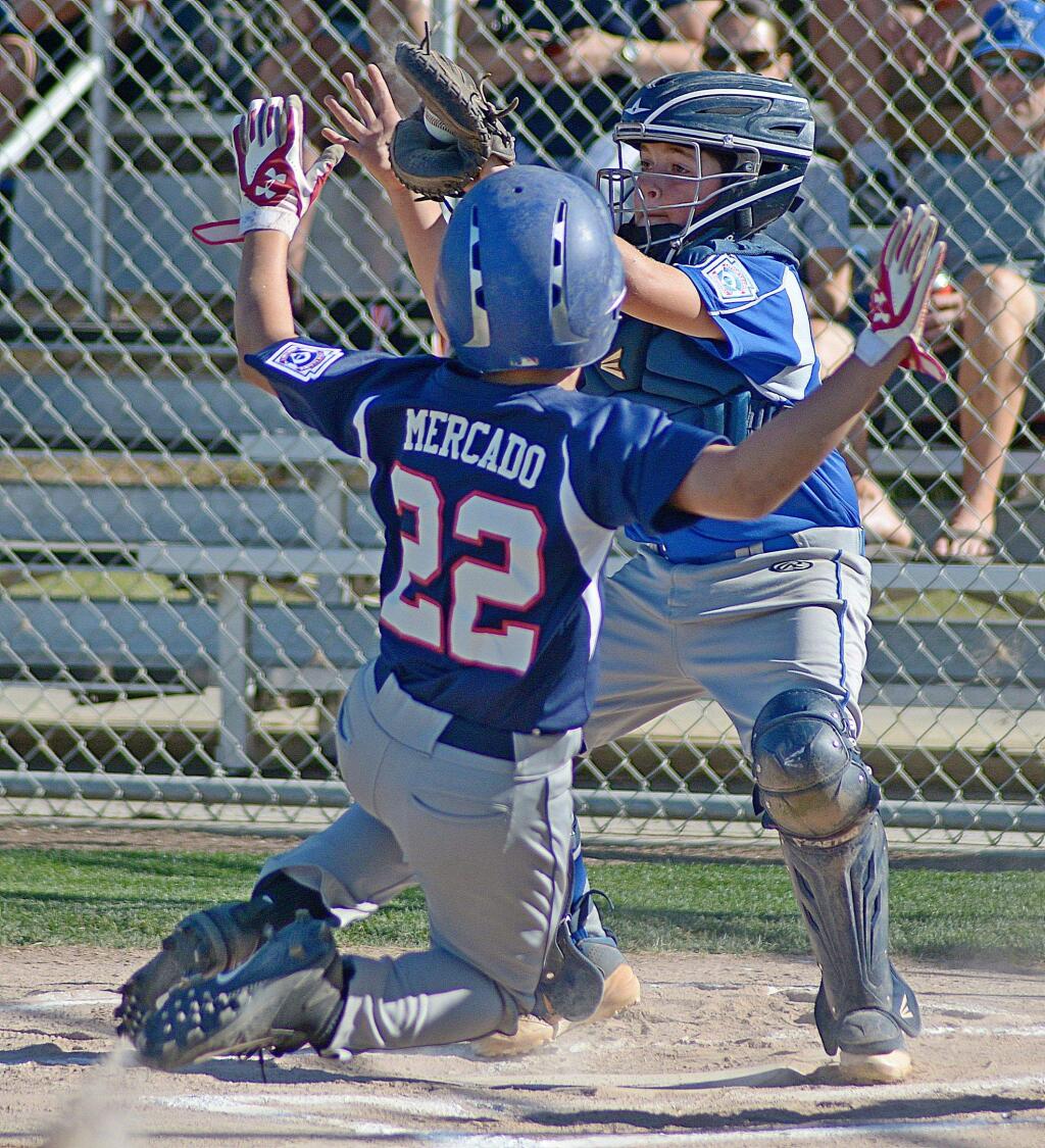 SUMNER FOWLER/FOR THE ARGUS-COURIERPetaluma American's Danny Mercado slides in under Petaluma Valley catcher Franco Bernardini in 11-year-old All-Star game won by the Americans, 10-4.