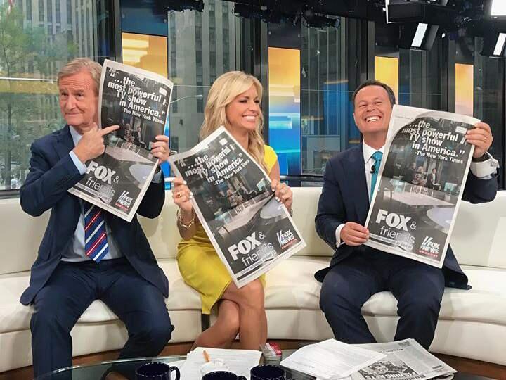 The hosts of “Fox & Friends” hold up the full page ad that ran in Thursday's New York Times, Washington Post and New York Post newspapers. (FACEBOOK)