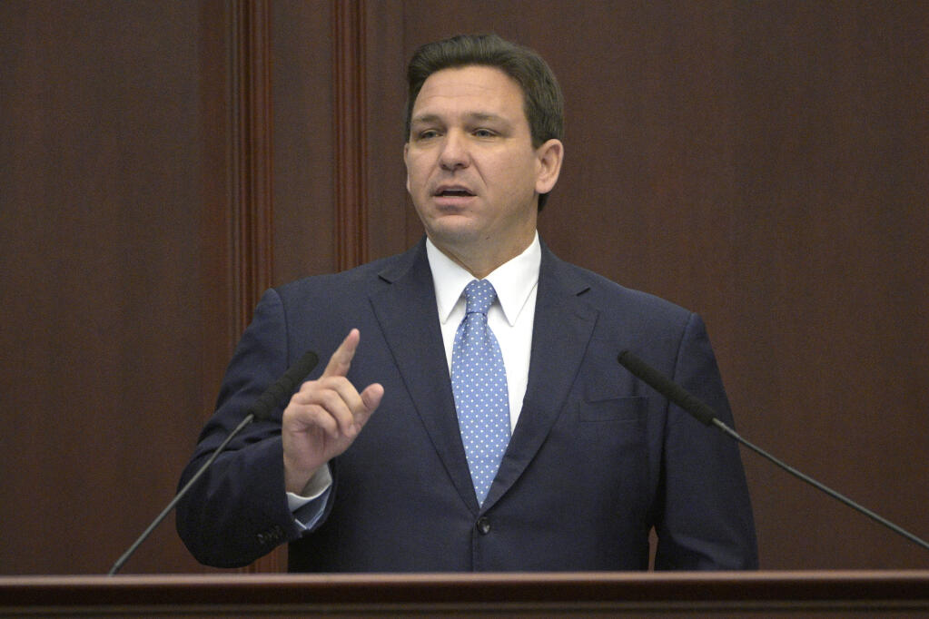 FILE - Florida Gov. Ron DeSantis addresses a joint session of a legislative session, Jan. 11, 2022, in Tallahassee, Fla. Florida Gov. DeSantis on Tuesday, April 19, asked the Legislature to repeal a law allowing Walt Disney World to operate a private government over its properties in the state, the latest salvo in a feud between the Republican and the media giant. (AP Photo/Phelan M. Ebenhack, File)