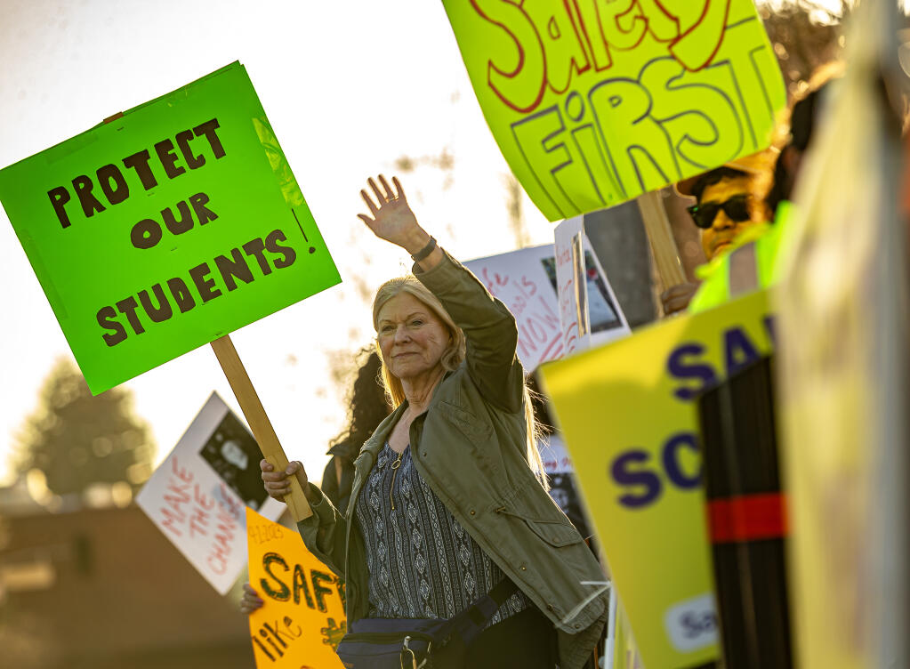 Members of the Safe Campus Alliance wave to motorists while protesting along Third Street in OldCourthouse Square before marching to City Hall to attend the Santa Rosa City School board meeting, Wednesday, Feb. 28, 2024. (Chad Surmick / The Press Democrat)