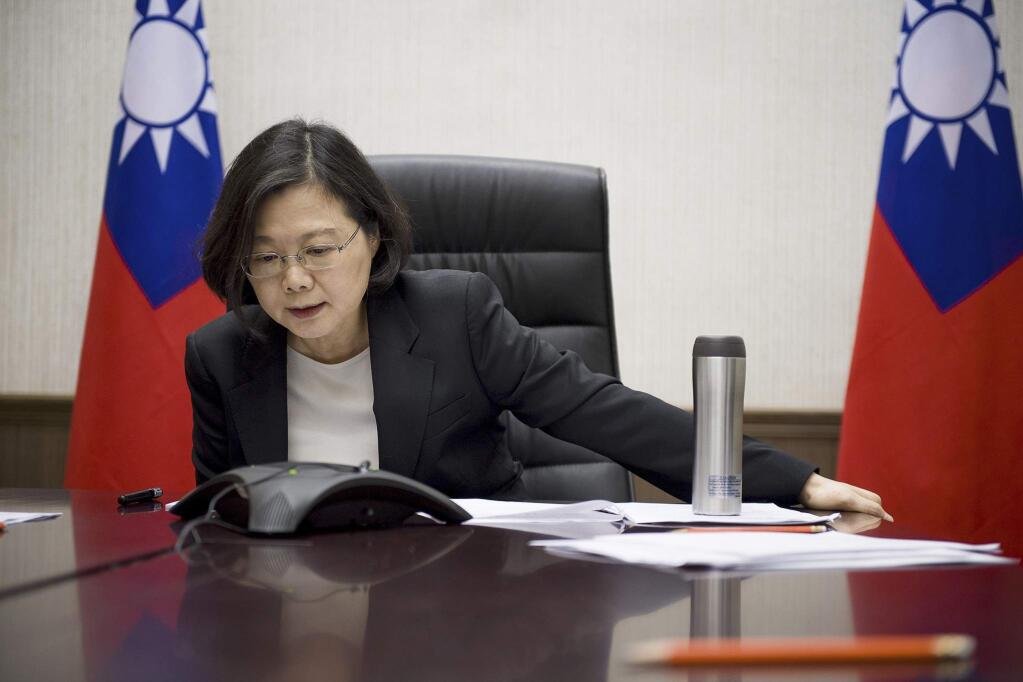 FILE - In this Friday, Dec. 2, 2016, file photo, released by Taiwan Presidential Office, Taiwan's President Tsai Ing-wen speaks with U.S. President-elect Donald Trump through a speaker phone in Taipei, Taiwan. China on Wednesday accused Taiwanese President Tsai Ing-wen of seeking to use a planned transit stop in the U.S. to score diplomatic points, amid Chinese rancor over an unprecedented phone call between Tsai and U.S. President-elect Donald Trump. (Taiwan Presidential Office via AP, File)