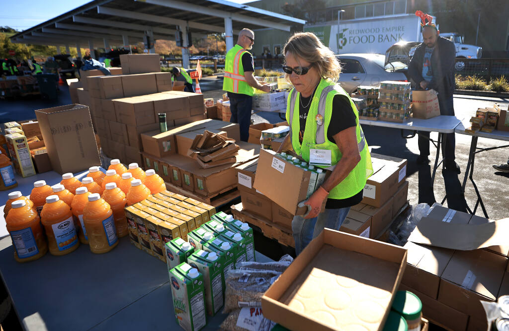 A Redwood Empire Food Bank volunteer sorts groceries. (KENT PORTER / The Press Democrat, 2021)