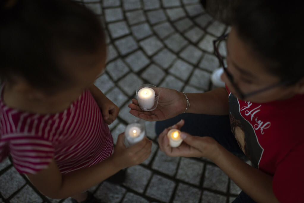 People at a candlelight vigil for the victims of the mass shooting at Robb Elementary School gather in downtown Houston on Tuesday evening, May 24, 2022. (Mark Felix/The New York Times)