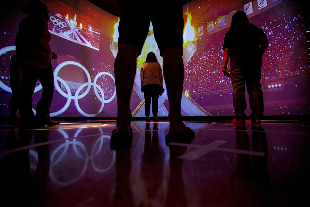 FILE - Visitors watch a simulation of the Parade of Nations exhibit during the opening day of the U.S. Olympic and Paralympic Museum in Colorado Springs Colo., on July 30, 2020. More than 27 months since it was greenlighted by Congress, the panel established to investigate the inner workings of the U.S. Olympic structure has yet to conduct a formal interview because of bureaucratic red tape and slow action from the same lawmakers who had expressed a pressing need for better oversight. The commission was created as part of the bipartisan “Empowering Olympic, Paralympic, and Amateur Athletes Act of 2020,” which itself came out of an 18-month investigation into how the U.S. Olympic and Paralympic Committee and the sports organizations it oversees mishandled sex-abuse cases in gymnastics and other sports. (Chancey Bush/The Gazette via AP, File)