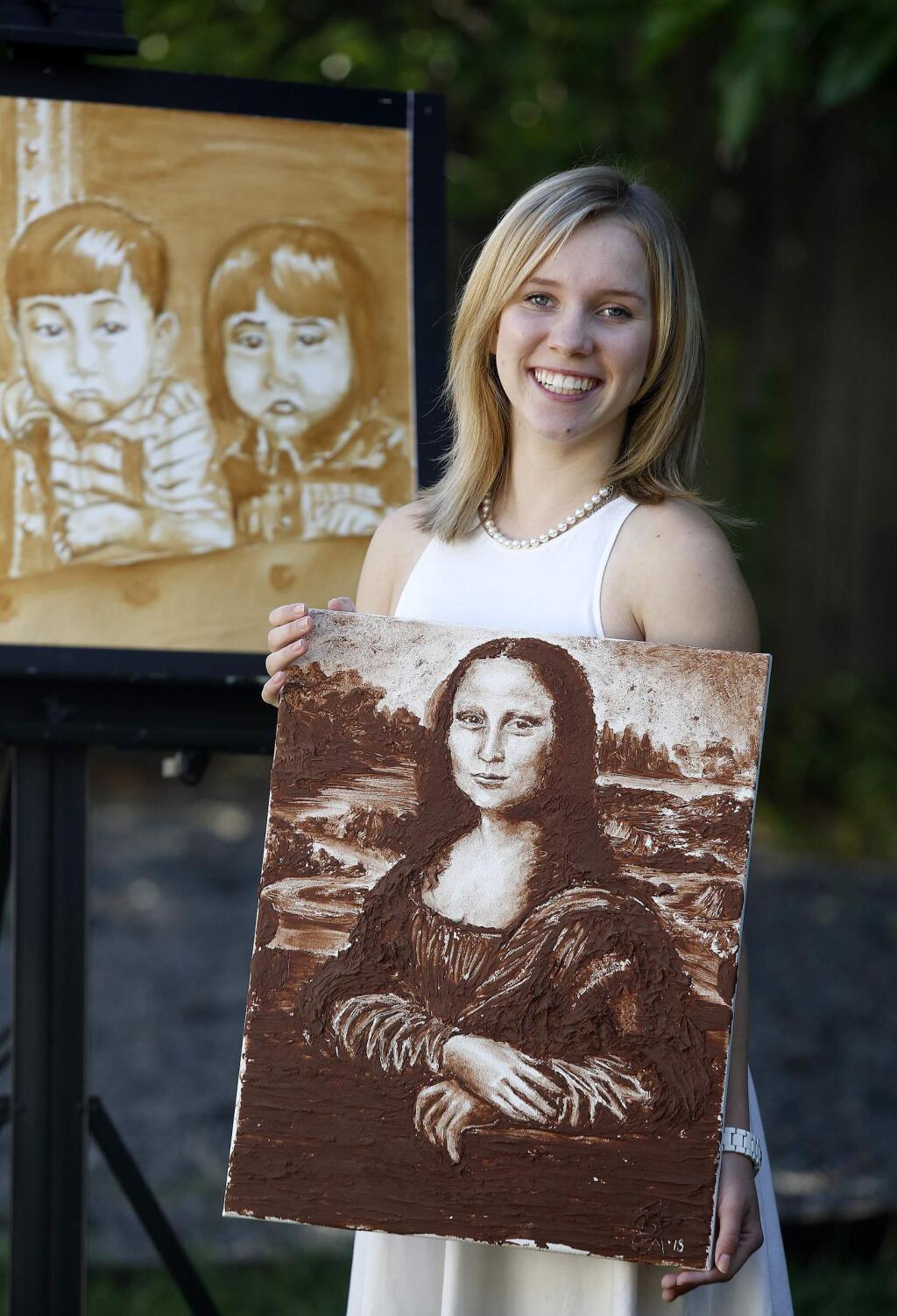 Bailey Farren, 17, holds a painting of the Mona Lisa made with chocolate frosting and behind her is a painting made with soy sauce. Photo taken at her home on Thursday, July 24, 2014 in Rohnert Park. (BETH SCHLANKER / The Press Democrat)