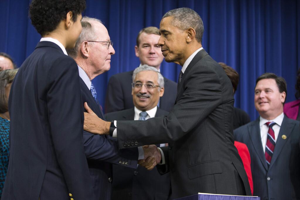President Barack Obama shakes hands with Senate Health, Education, Labor and Pension Committee Chairman Sen. Lamar Alexander, R-Tenn., a co-sponser of the 'Every Student Succeeds Act,' a major education law setting U.S. public schools on a new course of accountability, Thursday, Dec. 10, 2015, in Washington. The law will change the way teachers are evaluated and how the poorest performing schools are pushed to improve. Rep. Robert Scott, D-Va., ranking member on the House Education and the Workforce Committee is at center. (AP Photo/Evan Vucci)