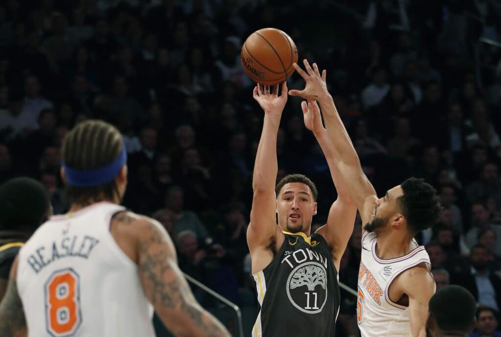 New York Knicks guard Courtney Lee, right, defends against Golden State Warriors guard Klay Thompson (11) during the first half of an NBA basketball game, Monday, Feb. 26, 2018 in New York. Knicks forward Michael Beasley (8) watches the action. (AP Photo/Kathy Willens)