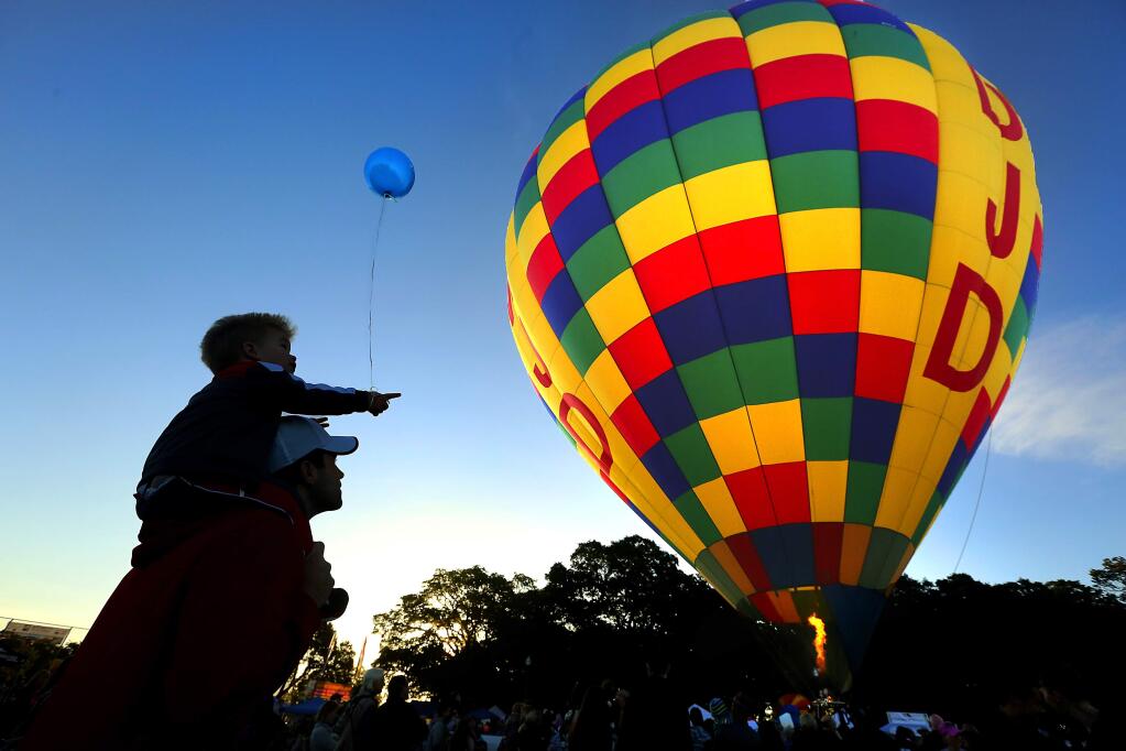 Jackson Brown, 1 1/2, rides on his dad Chris' shoulders as the hot air balloons launched from Keiser Park in Windsor. (JOHN BURGESS / PRESS DEMOCRAT)
