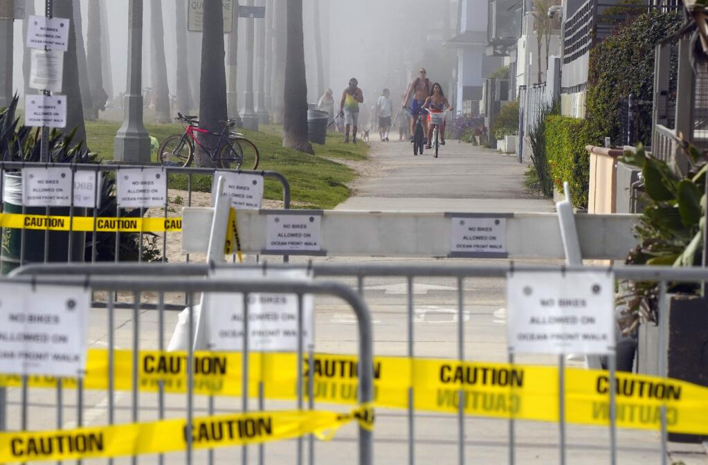 People utilize the Venice Beach Boardwalk during the coronavirus outbreak, Saturday, April 25, 2020, in the Venice section of Los Angeles. (AP Photo/Mark J. Terrill)