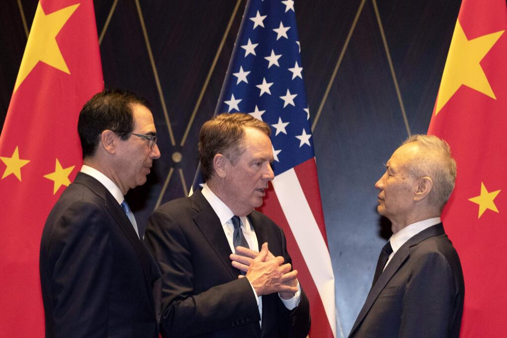 FILE - In this July 31, 2019, file photo U.S. Trade Representative Robert Lighthizer, center, gestures as he chats with Chinese Vice Premier Liu He, at right with Treasury Secretary Steven Mnuchin, left, looking on after posing for a family photo at the Xijiao Conference Center in Shanghai. The 13th round of U.S.-China trade negotiations is set to begin Thursday, Oct. 10 in Washington. (AP Photo/Ng Han Guan, Pool, File)