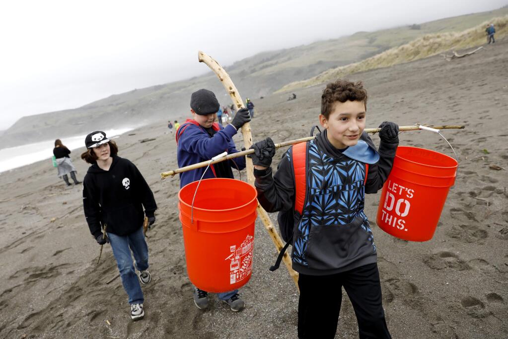 (From right) Javier Gutierrez, 11, Parker Jennings, 12, and Ben Silber, 11, all from Petaluma, walk along and pick up trash during the Sonoma Coast Stewardship Day at Goat Rock Beach in Jenner, on Saturday, February 4, 2017. (BETH SCHLANKER/ The Press Democrat)
