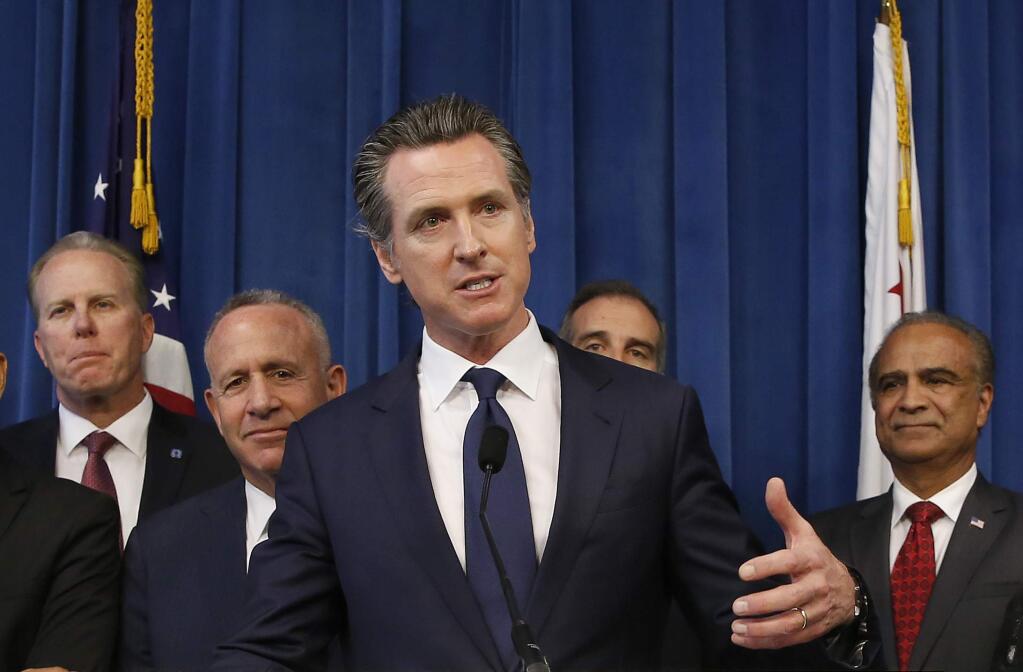 FILE - In this March 20, 2019, file photo Gov. Gavin Newsom, center, discusses the homeless problem facing California after a meeting with the mayors of some of the state's largest cities held at the Governor's office in Sacramento, Calif. Newsom sent a request letter, Tuesday, Jan. 21, 2020, to U.S. Housing and Urban Development Secretary Ben Carson asking the federal government to provide surplus federal land to deal with the state's homeless crisis. (AP Photo/Rich Pedroncelli, File)