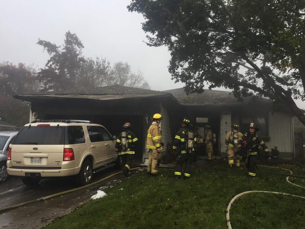 Petaluma and Rancho Adobe firefighters work at the scene of a house fire on Cerro Sonoma Circle in Petaluma on Monday, Nov. 21, 2016. (BETH SCHLANKER/ PD)