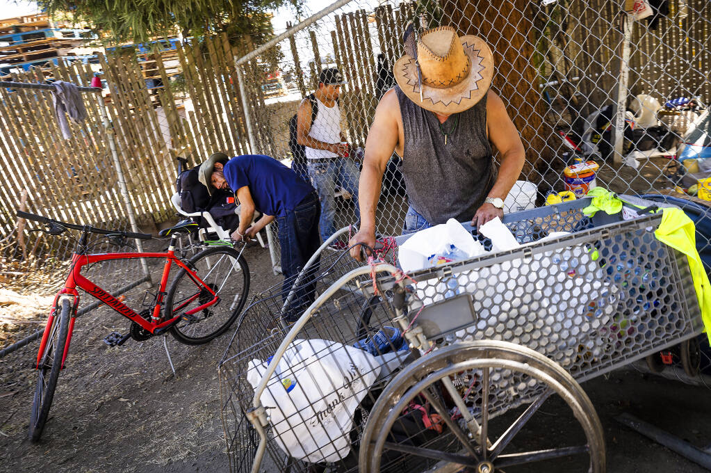 A group of homeless men pack their possessions into their bike-towed carts after authorities gave notice the Santa Rosa Joe Rodota Trail encampment would be cleared on Tuesday, July 26, 2022. (John Burgess/Sonoma Magazine)