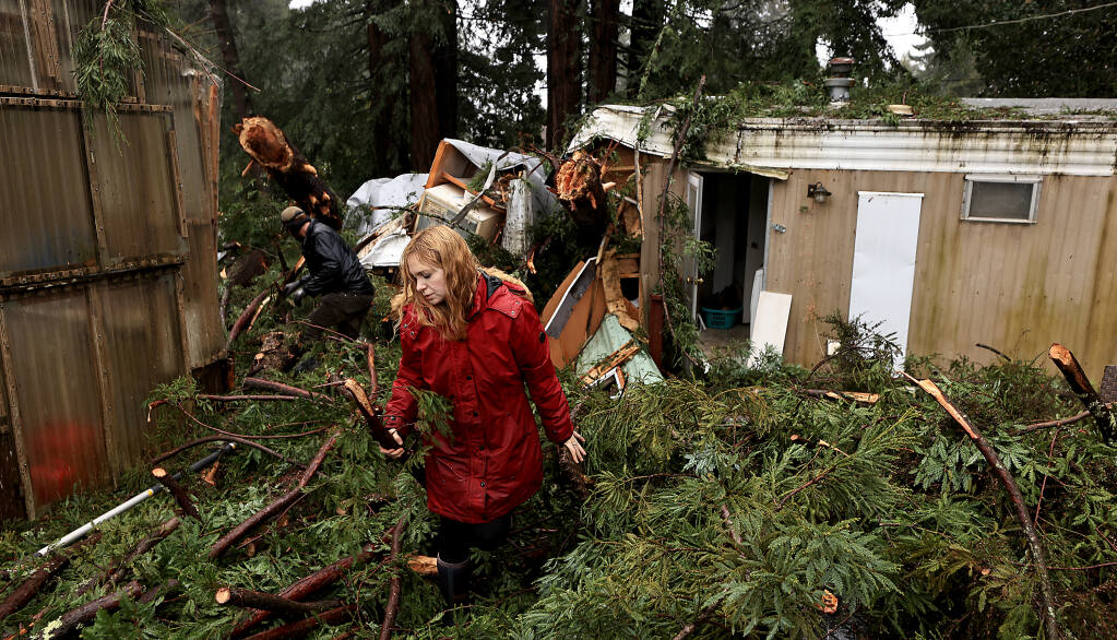 Friends and neighbors clear a path, Thursday, Jan. 5, 2023, to a mobile home where Aeon Tocchini, 2-1/2, died after trees fell on to the structure where he and his parents Dan and Aisha Tocchini were living, Wednesday night during the height of the storm in Occidental.  (Kent Porter/The Press Democrat)