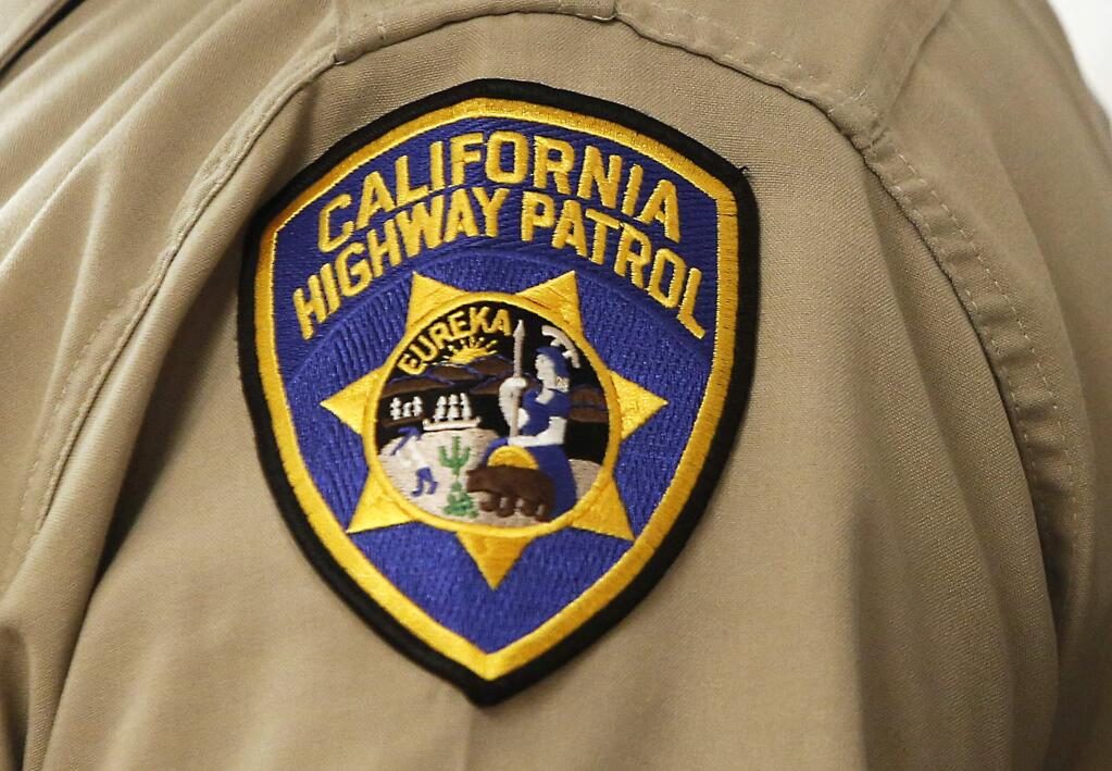 FILE - This March 26, 2014 file photo shows a shield on the uniform of a California Highway Patrol officer at the state Capitol in Sacramento, Calif. The California Highway Patrol has suspended the police powers of numerous officers and supervisors in the agency's East Los Angeles office after discovering fraudulent overtime records. Chief Mark Garrett of the agency's Southern Division said at a news conference Friday, Feb. 1, 2019, that an investigation has uncovered at least $360,000 in fraudulent overtime pay in 2017 and 2018. (AP Photo/Rich Pedroncelli, File)