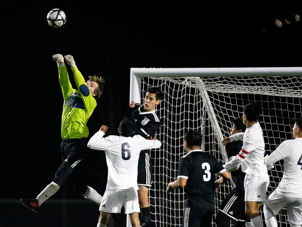 Healdsburg's goalkeeper Orion Von Rohr, far left, punches the ball away from the goal on a Rancho Cotate corner kick during the second half of a boys varsity soccer match between Rancho Cotate and Healdsburg high schools in Healdsburg on Thursday, January 31, 2019. (Alvin Jornada / The Press Democrat)