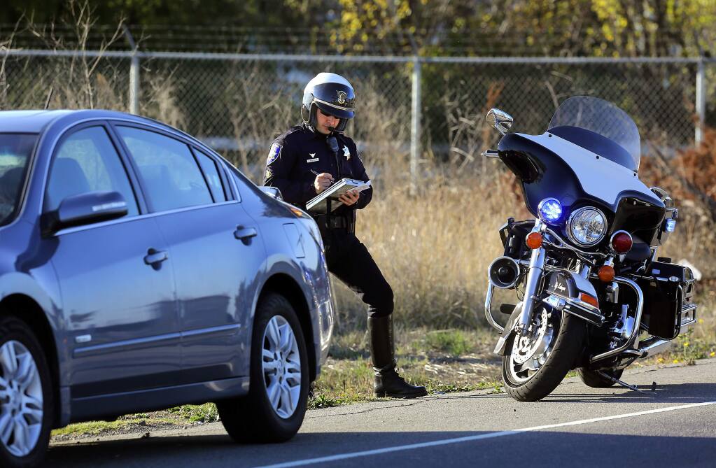 Officer C. Ricci writes a ticket for a speeding car pulled over on Lakeville Highway in Petaluma in 2013. (JOHN BURGESS/ PD FILE)