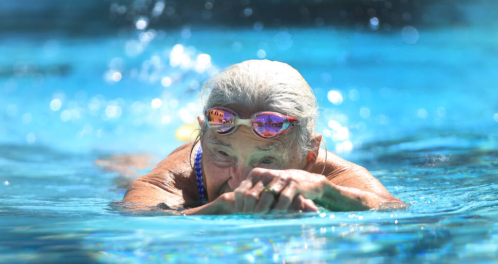 At 91 years old, Gail Roper uses a paddleboard to get limbered up and works out several days a week at a Healdsburg pool. Roper has been swimming since her teen years, and also appeared in the 1952 Olympic Games. Photo taken Thursday, March 25, 2021, in Healdsburg. (Kent Porter / The Press Democrat)