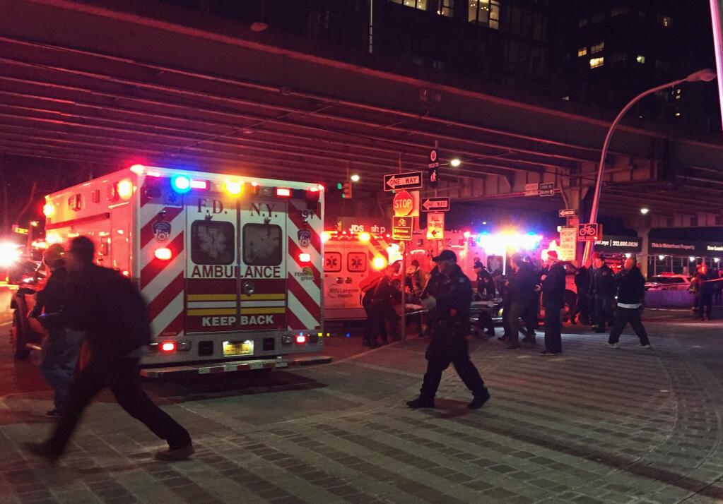 First responders carry a person to an ambulance after a helicopter crashed into the East River along New York on Sunday, March 11, 2018. A Federal Aviation Administration spokeswoman said Sunday the Eurocopter AS350 went down just after 7 p.m. Sunday in the waterway just north of Roosevelt Island and is 'reportedly inverted in the water.' (AP Photo/Jennifer Peltz)
