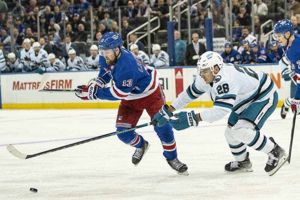 San Jose Sharks right wing Timo Meier, right, fights for control of the puck against Rangers left wing Alexis Lafreniere during the first period Thursday, Oct. 20, 2022, in New York. (Eduardo Munoz Alvarez / ASSOCIATED PRESS)