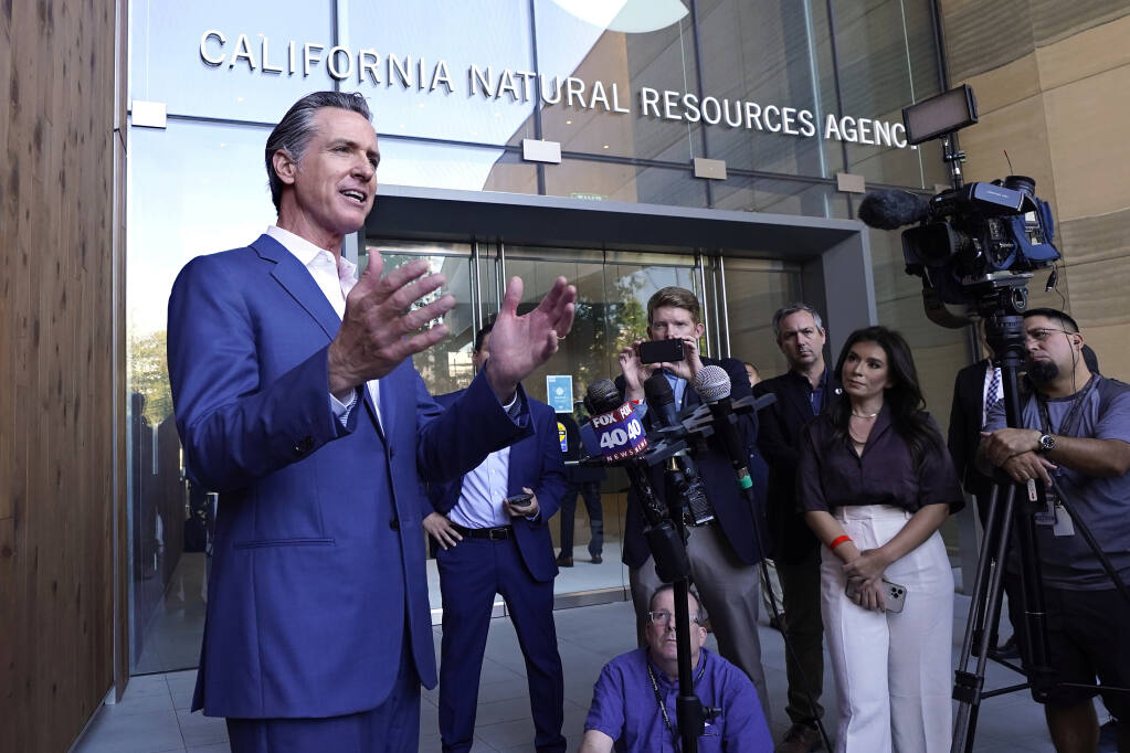 FILE - California Gov. Gavin Newsom speaks to reporters outside the California Natural Resources Agency in Sacramento, Calif., Oct. 7, 2022. Newsom says he plans to sign into law a pair of climate-focused bills intended to force major corporations to be more transparent about greenhouse gas emissions and financial risks stemming from global warming. (AP Photo/Rich Pedroncelli, File)