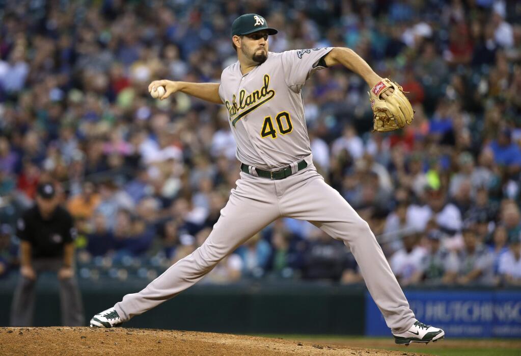 Oakland Athletics starting pitcher Jason Hammel throws in the first inning of a baseball game against the Seattle Mariners, Friday, Sept. 12, 2014, in Seattle. (AP Photo/Ted S. Warren)