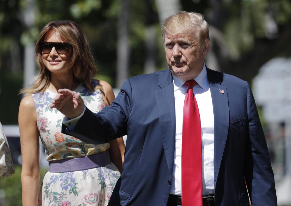 President Donald Trump, right, gestures as he and first lady Melania Trump, left, arrive for Easter services at Episcopal Church of Bethesda-by-the-Sea, Sunday, April 21, 2019, in Palm Beach, Fla. (AP Photo/Pablo Martinez Monsivais)