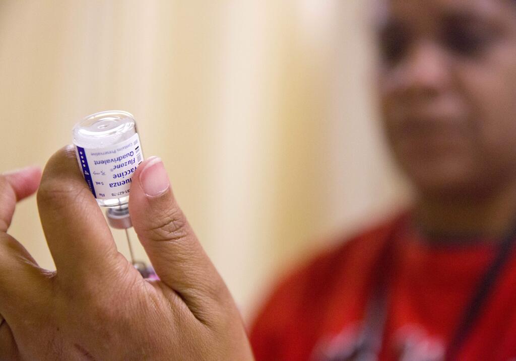 FILE - In this Wednesday, Feb. 7, 2018 file photo, a nurse prepares a flu shot from a vaccine vial at the Salvation Army in Atlanta. Most doses of vaccine are made in a production process that involves growing viruses in chicken eggs. (AP Photo/David Goldman)