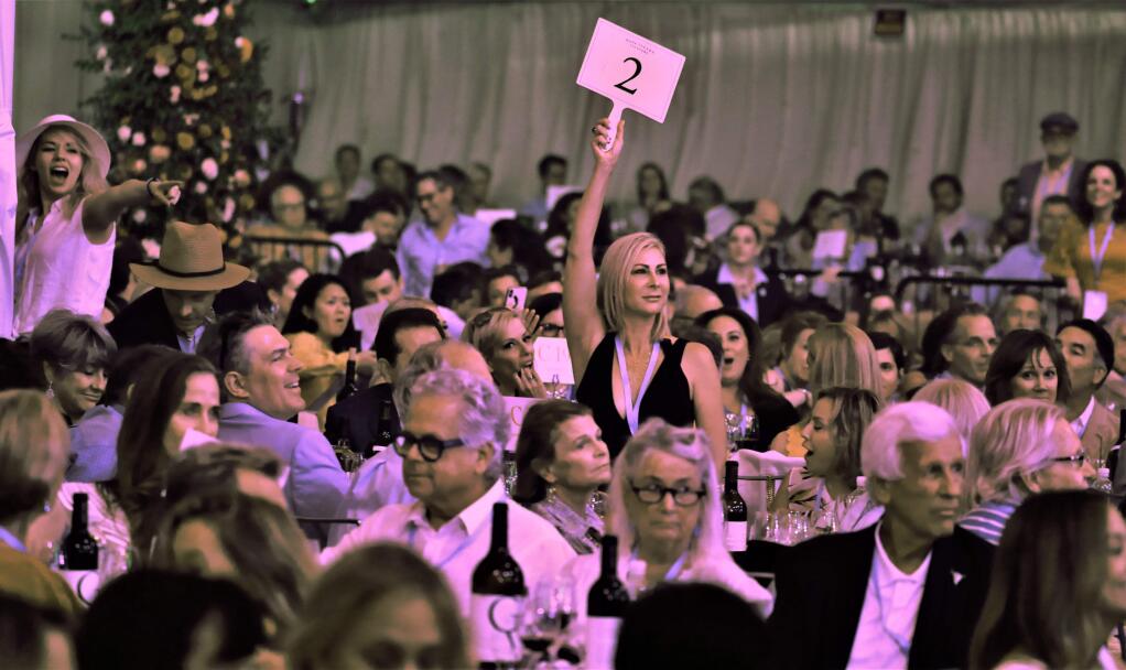 A guest casts the winning bid for a lot that sold for $520,000 at Auction Napa Valley at Meadowood Resort in St. Helena, Saturday, June 1, 2019. (Will Bucquoy/for The Press Democrat).