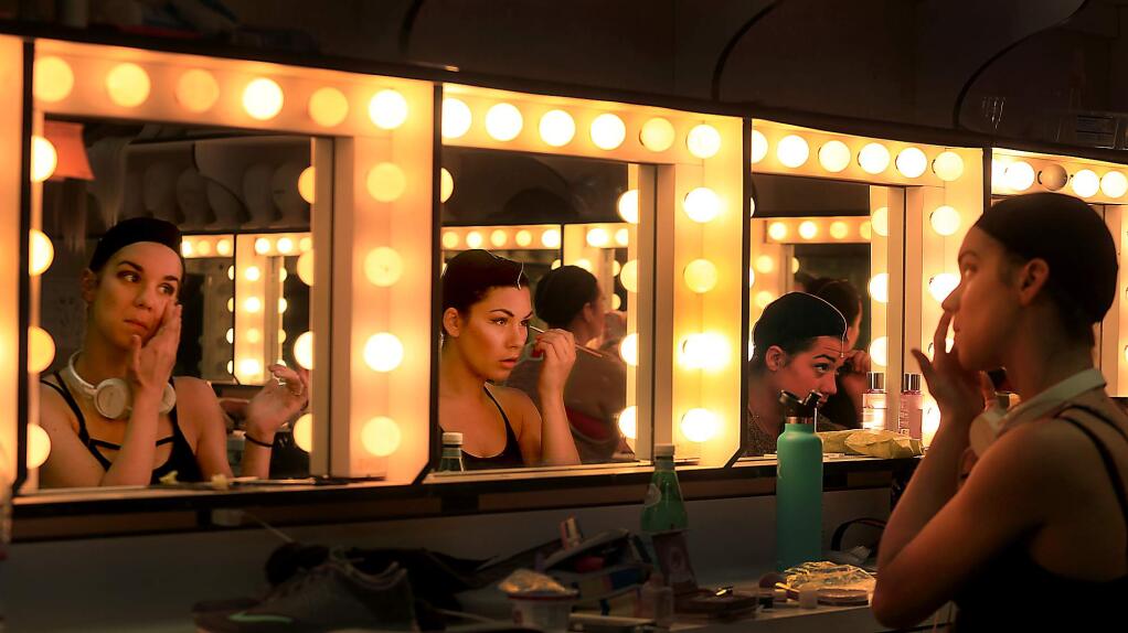 BACKSTAGE: Left, Alex Stewart prepares for a dress rehearsal of ‘Merrily We Roll Along'; above, Aubrey Reese, Michelle Owens and Sophie Madorsky apply makeup; right, Danielle Honeyman stretches.
