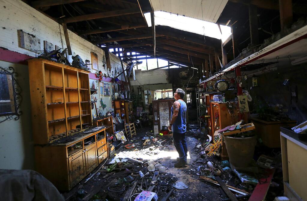 Vince Passanisi survey the damage from Thursday's fire at his store, Passanisi's Home and Garden in downtown Penngrove. The fire started in an attached shed behind the business and spread into the attic. (JOHN BURGESS / The Press Democrat)