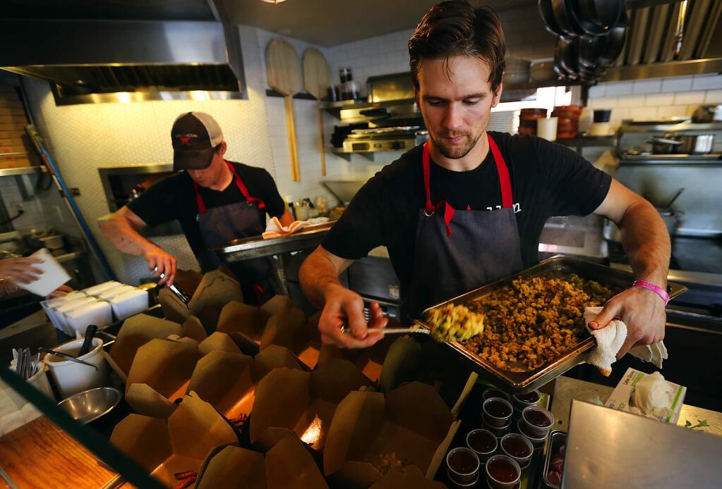 Chefs de partie Kyle Wanninger, right, and James Grimes fill to go containers with paleo-based food for the 4th week of the Lurong Challenge at the Glen Ellen Star restaurant. (JOHN BURGESS / The Press Democrat)
