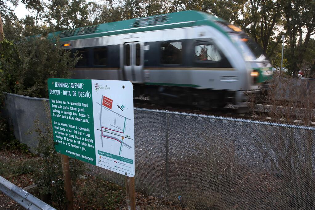 The SMART train passes by Jennings Ave. and a sign directing pedestrians to follow a 0.6 mile detour around the tracks in Santa Rosa on Wednesday, October 24, 2018. (BETH SCHLANKER/ The Press Democrat)